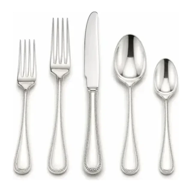 Five silver-colored flatware pieces arranged on white