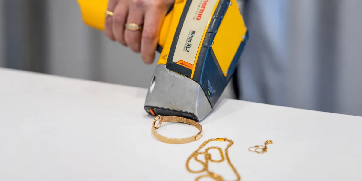 Gold jewelry being examined with metal-testing equipment; horizontally extended SDJB image